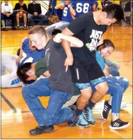  ?? Photo by Mike Eckels ?? After linking arms, members of the junior class tried to stand up together during the 2017 Decatur homecoming pep rally at Peterson Gym in Decatur on Friday. The senior class won the competitio­n.