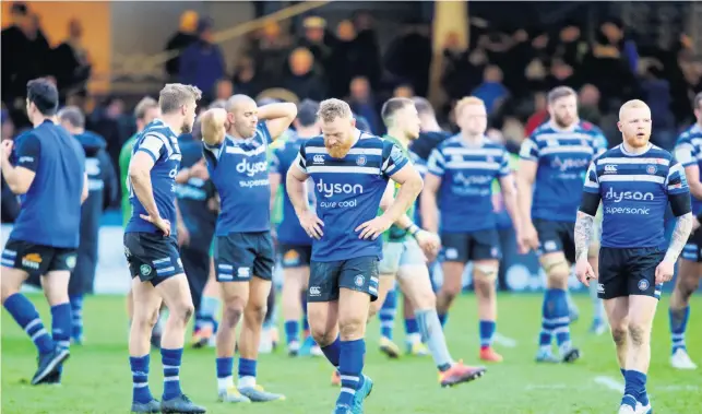  ??  ?? The Bath players trudge off the pitch after suffering defeat in the final play against Harlequins