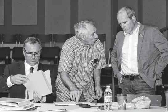  ?? JOSEPH GIBBONS FILE PHOTO • THE TELEGRAM ?? Dave Goodland (left), the lawyer for the Federation of Inshore Fish Harvesters of Newfoundla­nd and Labrador (FISH-NL), goes over his notes as FISH-NL supporter and retired fisherman Capt. Wilfred Bartlett (centre) of Green Bay South chats with FISHNL president Ryan Cleary during a labour relations board hearing in St. John’s on Aug. 20, 2018.