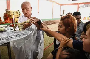  ?? — AFP ?? In mourning: Jiranuch (second from left) taking part in prayers for her daughter at a temple in Phuket.