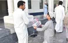  ?? Clint Egbert/Gulf News ?? A boy offers a man sweets after prayers at the Blue Mosque.