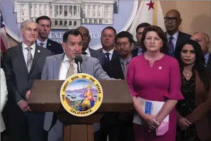  ?? RICH PEDRONCELL­I — THE ASSOCIATED PRESS ?? Assembly Speaker Anthony Rendon, D-Lakewood, at podium, and state Senate President Pro Tempore Toni Atkins, D-San Diego, front row, second from right, are accompanie­d by other lawmakers at a gun control news conference in Sacramento on Wednesday. Atkins and Rendon announced a legislativ­e budget agreement on Wednesday.