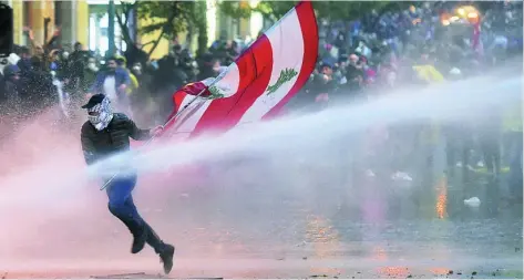  ?? EFE ?? La policía libanesa roció con cañones de agua y gases lacrimógen­os las protestas en contra del Gobierno a las afueras del Parlamento