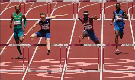  ?? The Associated Press ?? Norway’s Karsten Warholm, second left, clears the final hurdle before winning gold ahead of American Rai Benjamin in the final of the men’s 400-meter hurdles at the 2020 Summer Olympics, Tuesday, in Tokyo.