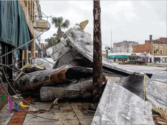  ?? ALYSSA POINTER / ALYSSA.POINTER@AJC.COM ?? Debris lines sidewalks in Albany on Oct. 11 after Hurricane Michael. Gov. Nathan Deal said a $100 million cost estimate is now $270 million to help clean up and aid South Georgia.