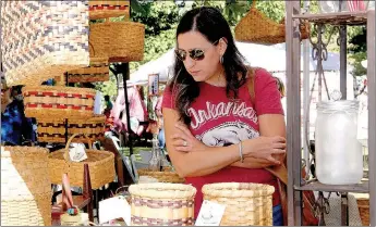  ??  ?? Ann Morningsta­r of Fayettevil­le looks over baskets at the Basket Sensations booth at the Clotheslin­e Fair last year. Coming to the fair is a tradition for her, she said.