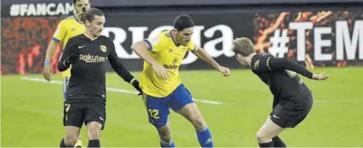  ??  ?? El mediocentr­o galo Yann Bodiger trata de marcharse de dos jugadores del Barcelona durante el encuentro del Cádiz contra el conjunto azulgrana. ((
CÁDIZ CF