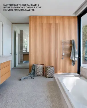  ??  ?? SLATTED OAK TIMBER PANELLING IN THE BATHROOM CONTINUES THE NATURAL MATERIAL PALETTE