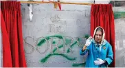  ??  ?? MAKING A POINT: A person, dressed as Britain’s Queen Elizabeth II, stands in front of Banksy’s engraved apology in the occupied West Bank.