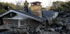  ?? PHOTO: MARCIO JOSE SANCHEZ/AP ?? BIG MESS: A firefighte­r surveys the surroundin­g damage from the roof of a house in Montecito.