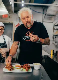  ?? ?? Guy Fieri takes a bite during a recent shoot for “Diners, Drive-ins and Dives” at Moo Yai Thai in Sea Bright, N.J.