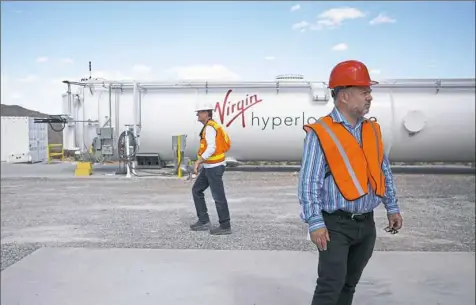  ??  ?? Pittsburgh native and head engineer Rob Ferber, right, and James Mitcheltre­e, tech innovation project manager, work at the testing site of the Virgin Hyperloop One.