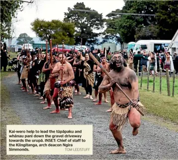  ?? TOM LEE/STUFF ?? Kai-wero help to lead the tūpāpaku and whānau pani down the gravel driveway towards the urupā . INSET: Chief of staff to the Kiingitang­a, arch deacon Ngira Simmonds.