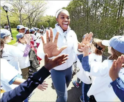  ?? ARNOLD GOLD — NEW HAVEN REGISTER ?? Profession­al tennis player Sloane Stephens, center, share high-fives with third graders from New Haven Public Schools during a free tennis clinic at the Connecticu­t Tennis Center courts in New Haven Tuesday.