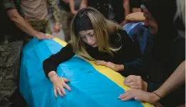  ?? EMILIO MORENATTI/AP 2022 ?? Anastasiia Okhrimenko cries over the coffin of her husband, Yurii Stiahliuk, Aug. 31 in Bucha, Ukraine. Stiahliuk was killed on the country’s eastern front.