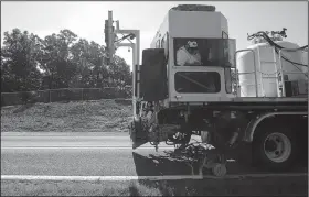  ?? Arkansas Democrat-Gazette/STATON BREIDENTHA­L ?? Brian Hayes with the Arkansas Highway and Transporta­tion Department works Thursday morning painting a side stripe on Arkansas 216 near Houston.