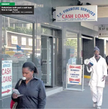  ?? PICTURE: IAN LANDSBERG ?? CREDIT Pedestrian­s walk past a cash loan firm in Cape Town