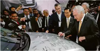  ?? Cesar Itiberê/PR/AFP ?? O presidente Michel Temer assina carro na abertura do Salão do Automóvel (SP)