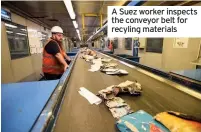  ??  ?? A Suez worker inspects the conveyor belt for recyling materials