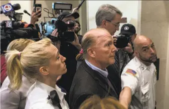  ?? Ruby Wallau / New York Times ?? Officers escort Mario Batali out of the courthouse after his arraignmen­t in Boston. The celebrity chef entered a plea of not guilty to indecent assault and battery of a woman.