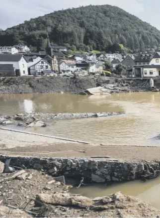  ?? ?? Destroyed houses, roads and a bridge in the aftermath of catastroph­ic flash