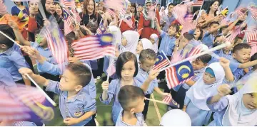  ??  ?? Kemas pre-schoolers wave the Jalur Gemilang during a session of the programme jointly run by the Marine Police and the Rural and Regional Developmen­t Ministry.