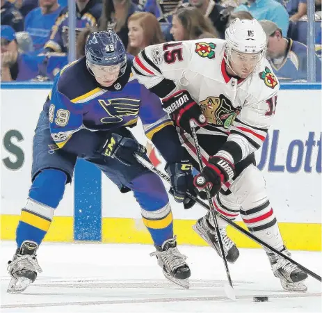  ?? | JEFF ROBERSON / AP ?? Hawks center Artem Anisimov battles for a loose puck with the Blues’ Ivan Barbashev in the first period Wednesday in St. Louis.