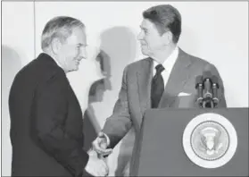  ??  ?? In this May 8, 1984file photo, David Rockefelle­r, left, chairman of the Council Americas, shakes hands with President Ronald Reagan at the State Department in Washington.