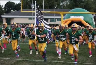  ?? RANDY MEYERS — THE MORNING JOURNAL ?? Christian Velez leads the Amherst Comets onto the field and holds the Fallen Officers Memorial Flag in honor of his father, Trooper Kenny Valez, on Sept. 16. Tooper Valez was killed in the line of duty on Sept. 15.