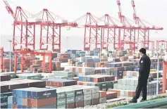  ??  ?? A man watches containers at the Yangshan deepwater port in Shanghai in this file photo. China will be singled out for special attention under new trade rules to limit excessivel­y cheap imports into the European Union, a European Commission official...