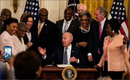  ?? Washington Post ?? Vice President Kamala Harris and members of Congress join President Joe Biden at the White House in Washington, D.C., as he signs the Juneteenth National Independen­ce Day Act into law on June 17, 2021.