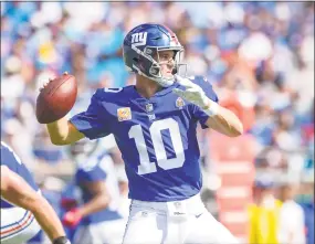  ?? Mike McCarn / Associated Press ?? New York Giants quarterbac­k Eli Manning looks to pass during the first half against the Carolina Panthers on Sunday. The Giants lost 33-31 and fell to 1-4.