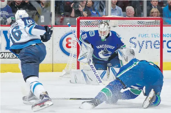  ?? — GETTY IMAGES ?? Winnipeg Jets forward Shawn Matthias fires a shot at Canucks goalie Jacob Markstrom Thursday at Rogers Arena as the host Canucks lost 4-2 to Winnipeg in Brock Boeser’s season debut. The rookie Boeser assisted on Daniel Sedin’s game-opening goal.