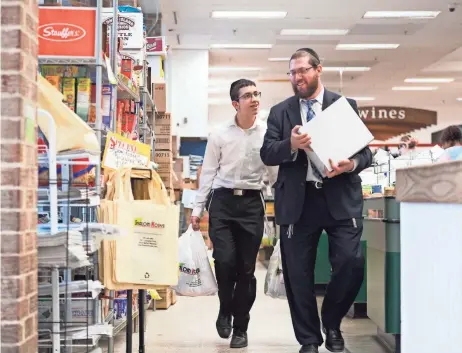  ?? PHOTOS BY JARRAD HENDERSON, USA TODAY ?? Rabbi Michael Frank, 40, and his son Meir Frank, 15, finish shopping Wednesday in Silver Spring, Md., for Passover. After thousands of years, Passover food is getting a makeover to cater to those who want contempora­ry and fun fare.