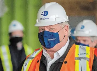  ?? FRANK GUNN THE CANADIAN PRESS ?? Ontario Premier Doug Ford arrives on a constructi­on site in Toronto on Thursday. Ford said the province was considerin­g a plea from two hot spots — Toronto and Peel Region — to stay locked down for two more weeks.