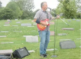  ?? FRIENDS OF THE CAL-SAG TRAIL ?? “Harmonica Neil” Florek performs a song by blues musician Jimmy Rogers by his gravesite during the 2019 Cal-Sag Graveyard Blues Tour organized by the Friends of the Cal-Sag Trail. This year’s tour is Sept. 9.