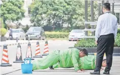  ??  ?? A man supervises as two workers do push-ups in downtown Shanghai on September 4. Asian shares rose yesterday, with markets reversing earlier losses, but investors were apprehensi­ve as the Sino-US trade dispute threatened to escalate this week and Argentina’s austerity measures rattled emerging markets. — AFP photo