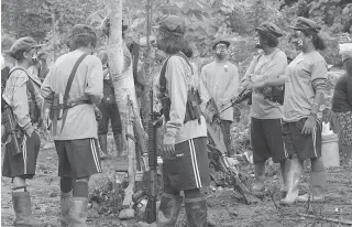  ?? PHOTO BY RENE DILAN ?? SAFE FOR NOW Women fighters of the New People’s Army chat at their camp in Quezon province.