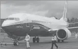  ?? REUTERS ?? Ground crew members escort a Boeing 737 MAX as it returns from a flight test at Boeing Field in Seattle, Washington.