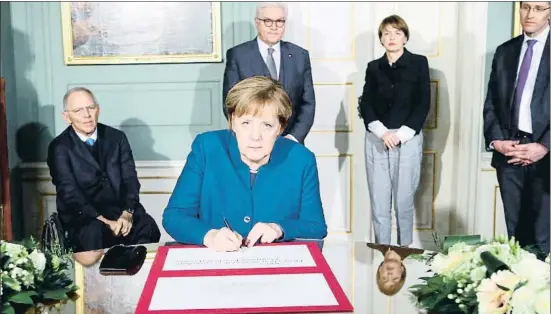  ?? JENS-ULRICH KOCH / EFE ?? Angela Merkel, canciller de Alemania, firmando ayer el documento conmemorat­ivo del centenario de Weimar