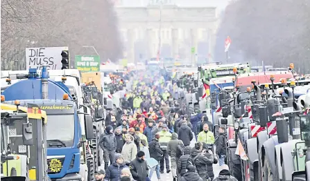  ?? ?? Tractors and trucks are lined up in front of Berlin’s landmark the Brandenbur­g Gate during a protest of farmers and truck drivers in Berlin.