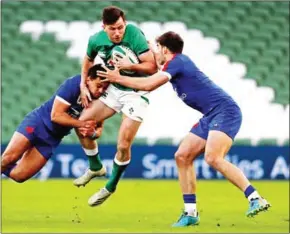  ?? POOL/AFP ?? Ireland’s full-back Hugo Keenan (centre) is tackled by France’s centre Arthur Vincent (left) and France’s wing Damian Penaud during the Six Nations internatio­nal rugby union match between Ireland and France at the Aviva Stadium in Dublin on Saturday.