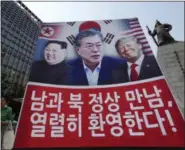  ?? AHN YOUNG-JOON — THE ASSOCIATED PRESS ?? A banner showing U.S. President Donald Trump, right, South Korean President Moon Jae-in and North Korean leader Kim Jong Un, left, is displayed to support the summit between two Koreas in Seoul, South Korea, Friday. The sign reads “We welcome the...