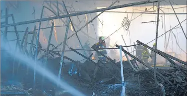  ?? REUTERS ?? Rescuers work at a site of a shopping mall hit by a Russian missile strike, in Kremenchuk, in Poltava region, Ukraine. Firefighte­rs and soldiers searched for survivors in the rubble after at least 18 people were killed. 21 people were said to be missing.