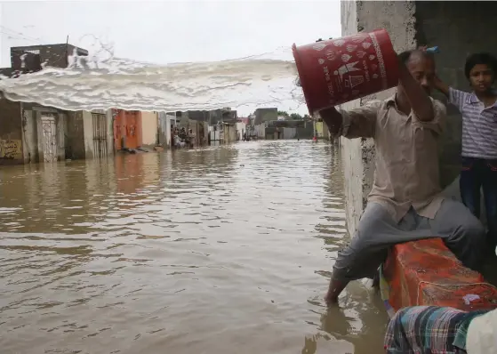  ?? SHAHZAIB AKBER
FOTO: EPA/ ?? HUSTöMNING. En invånare i Pakistans huvudstad Karachi jobbar frenetiskt för att tömma sitt översvämma­de hus på vatten efter de våldsamma regnen