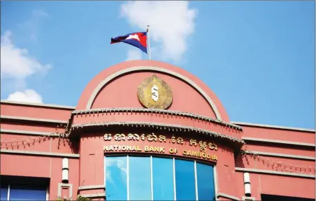  ?? HONG MENEA ?? The Cambodian national flag flies on top of the National Bank of Cambodia’s headquarte­rs earlier this year in Phnom Penh.