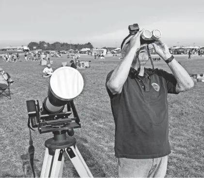  ?? ROB KERR/AFP VIA GETTY IMAGES ?? Jerry Potter observes the first stages of the total solar eclipse Aug. 21, 2017, in Madras, Oregon. Emotional sky-gazers stood transfixed across North America as the sun vanished behind the moon.