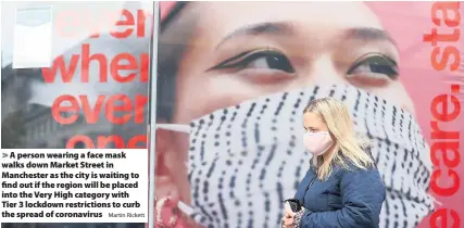  ?? Martin Rickett ?? A person wearing a face mask walks down Market Street in Manchester as the city is waiting to find out if the region will be placed into the Very High category with Tier 3 lockdown restrictio­ns to curb the spread of coronaviru­s