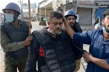  ?? — AFP ?? Policemen help an injured colleague during a clash with supporters of the Tehreek-e-labaik Pakistan party in Lahore.