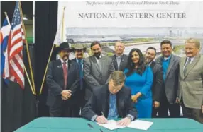  ?? Helen H. Richardson, Denver Post file ?? Colorado Gov. John Hickenloop­er signs HB15-1344 at the National Western Events Center in Denver in 2015. Tony Frank, one of the bill’s sponsors, is standing behind Hickenloop­er, third from the left.